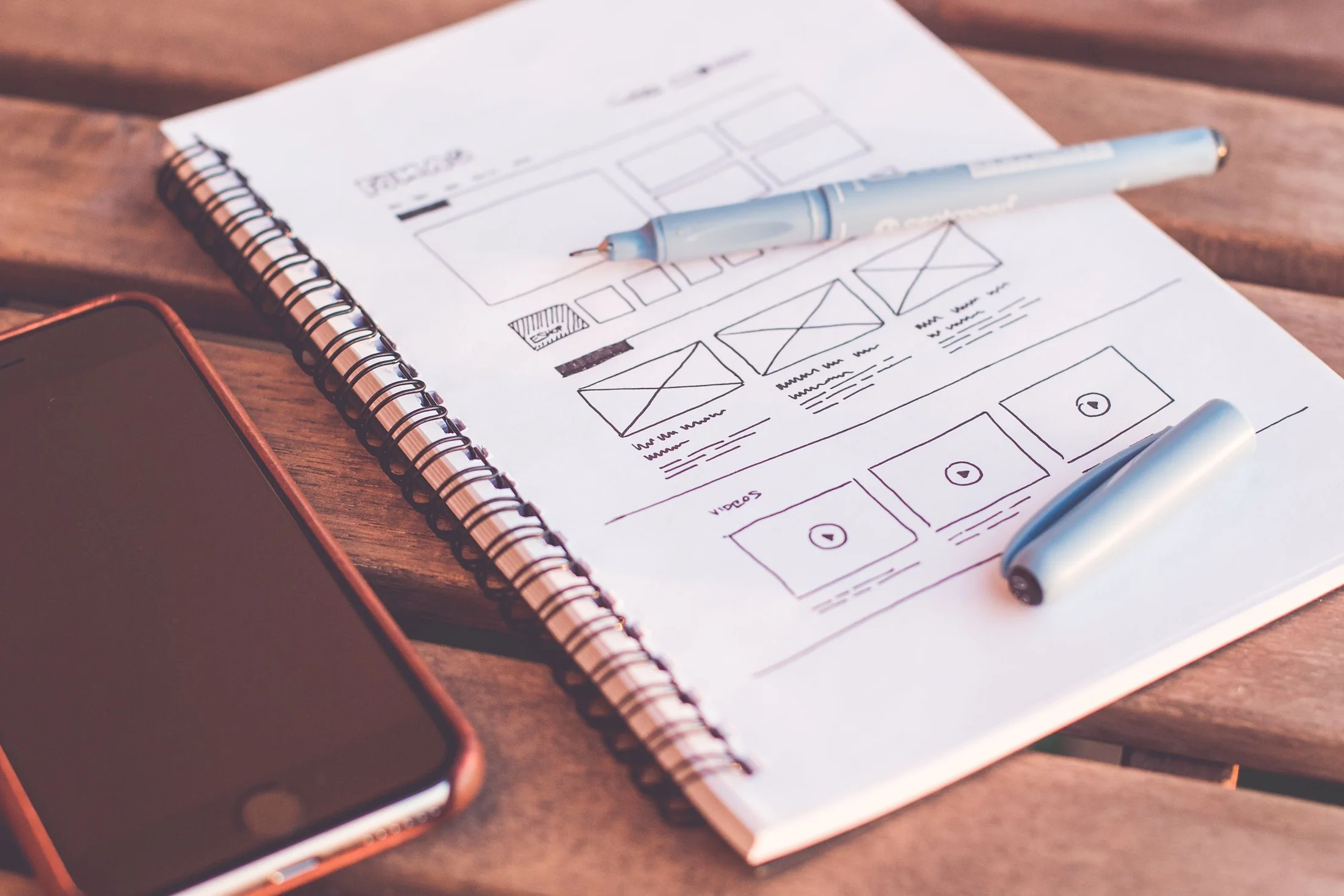 Wireframes d'une interface mobile dessinés dans un carnet.